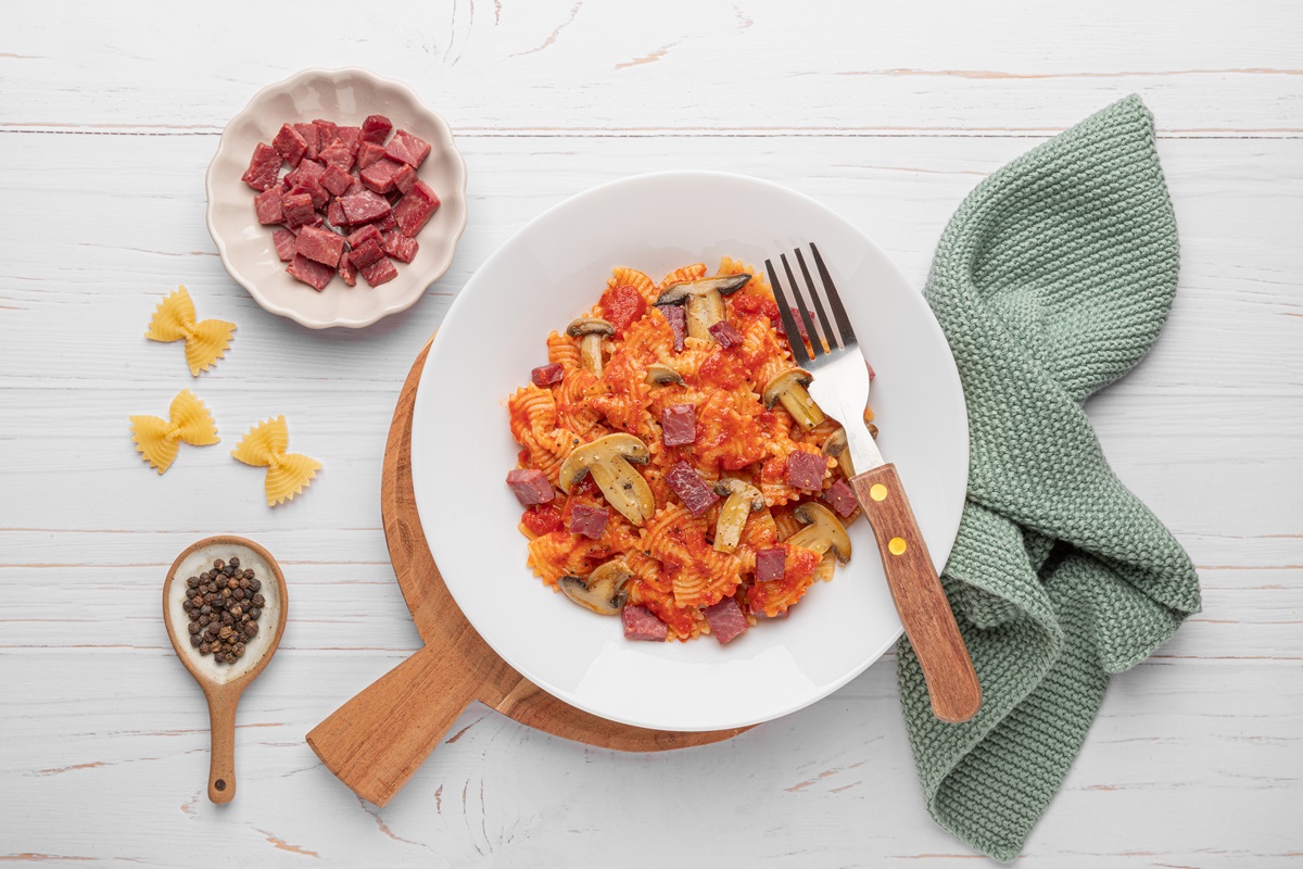 Farfalle al pomodoro, prosciutto di struzzo e funghi champignon